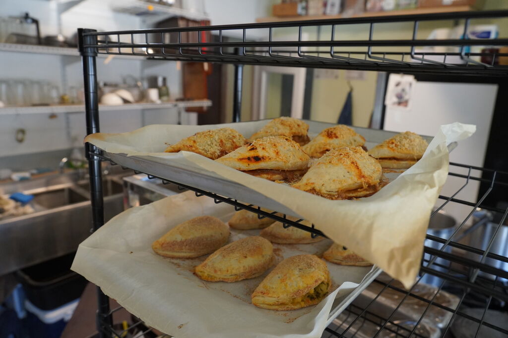 Trays of fresh hand pies on a cooling rack in the kitchen
